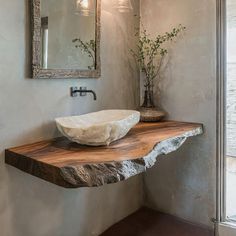 a bowl shaped sink sitting on top of a wooden counter next to a wall mounted mirror