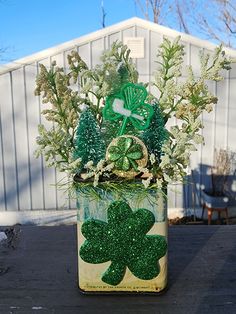 a st patrick's day flower arrangement in a tin can with shamrocks on it