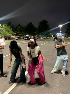 four people standing in a parking lot at night