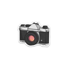 the camera sticker is shown on a white background and has an orange lens in it