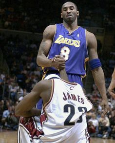 a basketball player holding onto another player on the court