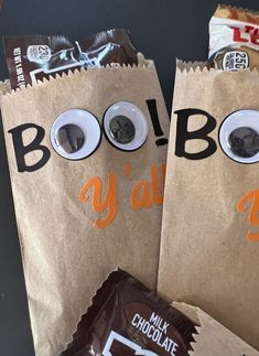 two brown bags with googly eyes and chocolate bars in them are sitting next to each other