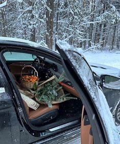 the back window of a car is covered in snow and there are many items piled on top of it