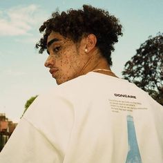 a young man with freckles on his shirt