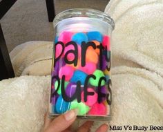 a person holding a glass jar filled with colorful confetti and the words party stuffs written on it