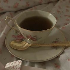 a cup of tea on a saucer with a spoon