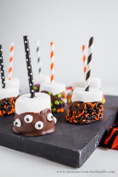 halloween desserts with chocolate and marshmallows are on a black slate board