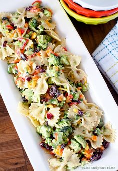 pasta salad with broccoli and cranberries on a white plate