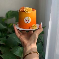 a person holding a cake with flowers on it