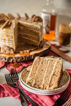 a slice of cake on a plate with fork and knife next to the rest of the cake