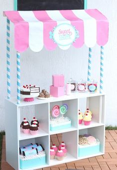 an ice cream stand with cupcakes and cakes on it's shelves for sale