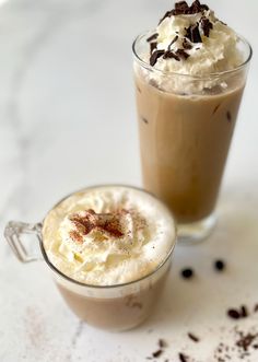 two cups filled with different types of desserts on top of a table next to each other