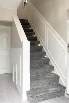 some stairs with lights on them in a house or office area that is white and grey