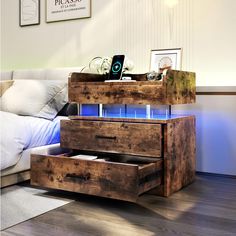 a wooden table with drawers on top of it in front of a couch and white pillows