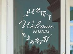 a glass door with the words welcome friends written on it and a wreath in front