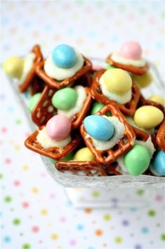 some kind of candy with pretzels on top in a glass bowl next to polka dot table cloth