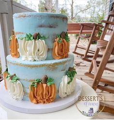 a three tiered cake decorated with pumpkins and leaves