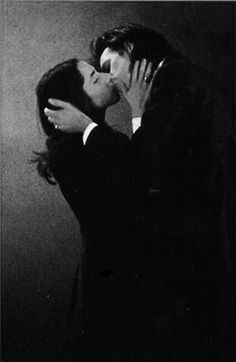 a black and white photo of two people kissing