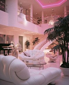 a living room filled with white furniture and a grand piano in the middle of it