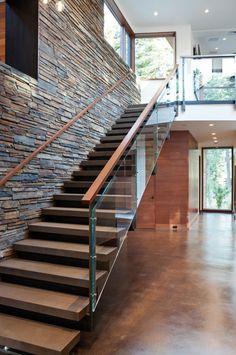 the stairs in this house are made out of wood and glass, with metal handrails