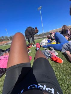 a person laying on the ground with their feet up in front of them and other people standing around