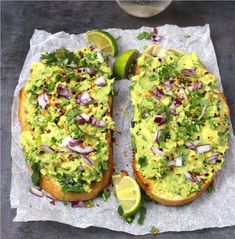 two pieces of bread topped with guacamole, onions and cilantro