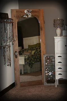 a mirror sitting on top of a wooden dresser next to a white chest of drawers