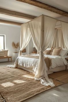 a bedroom with four poster bed and white drapes on the canopy over it's head