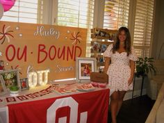 a woman standing next to a table with pictures on it