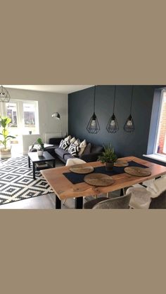 a living room filled with furniture and a wooden table in front of a large window