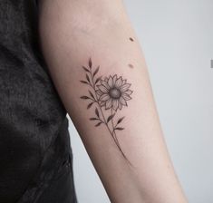 a woman's arm with a sunflower tattoo on the left side of her arm