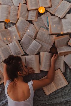 a woman laying on the floor surrounded by books