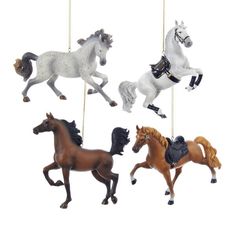 four toy horses hanging from strings on a white background