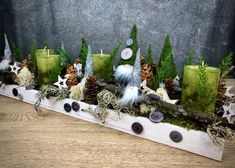 an arrangement of pine cones, candles and other decorations