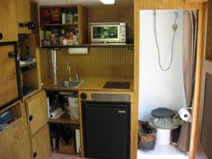 a small kitchen with wooden cabinets and appliances