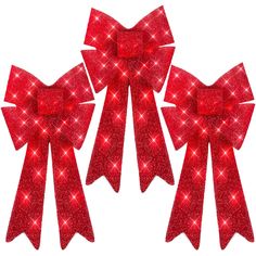 three red bows with sparkling lights on them