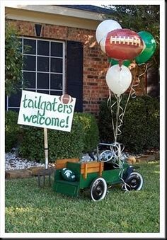 a football themed welcome sign in front of a brick house with balloons attached to it