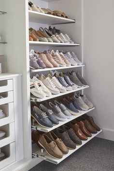 a white closet filled with lots of pairs of shoes next to a wall mounted shoe rack