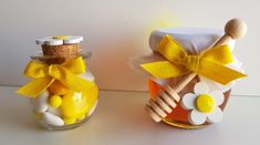 two jars filled with yellow and white candies, one has a wooden spoon in it