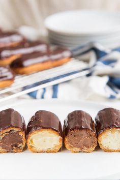 chocolate eclairs on a plate with the text perfect classic chocolate eclairs