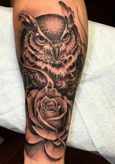 an owl with a rose tattoo on its leg is shown in black and grey colors