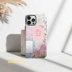 a phone case sitting on top of a white table next to a potted plant