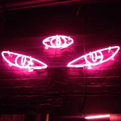 two neon lights that are on the side of a brick wall