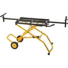 a small yellow cart with wheels on the top and two black bars attached to it