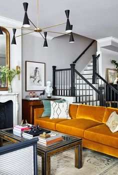 a living room filled with furniture and a fire place in front of a stair case