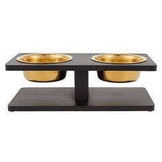 two black and gold bowls sitting on top of a wooden stand in front of a white background