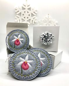 three blue and white christmas ornaments sitting on top of a table next to snowflakes