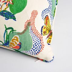 a white pillow with colorful flowers and butterflies on it