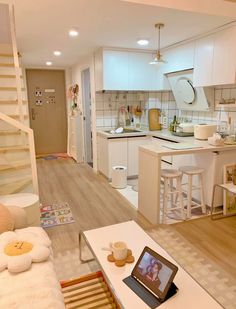 a living room filled with furniture next to a kitchen and dining area in a home