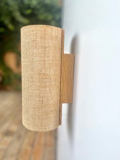 a close up of a wall light on a wooden surface with trees in the background